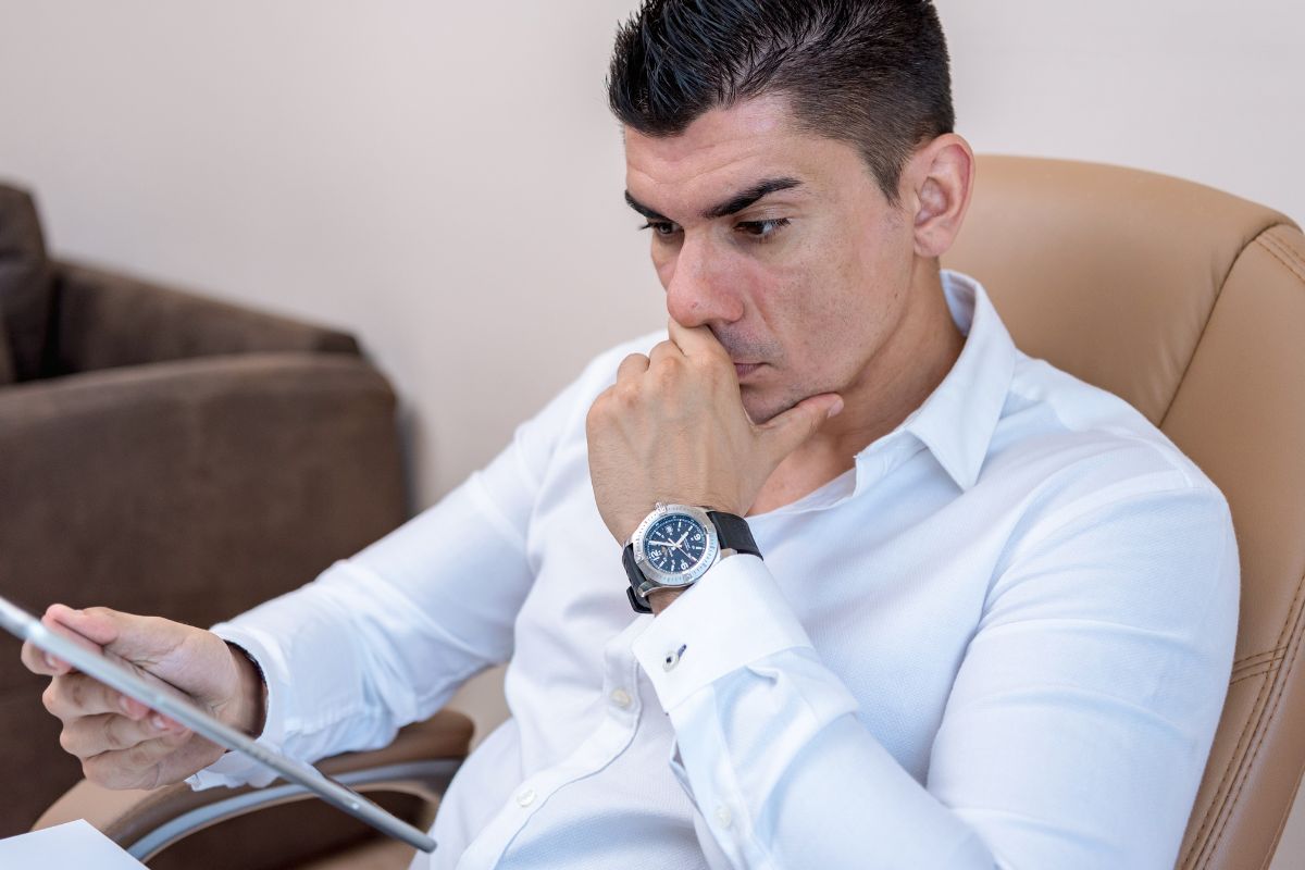 A foto de um homem olhando para seu gadget. 