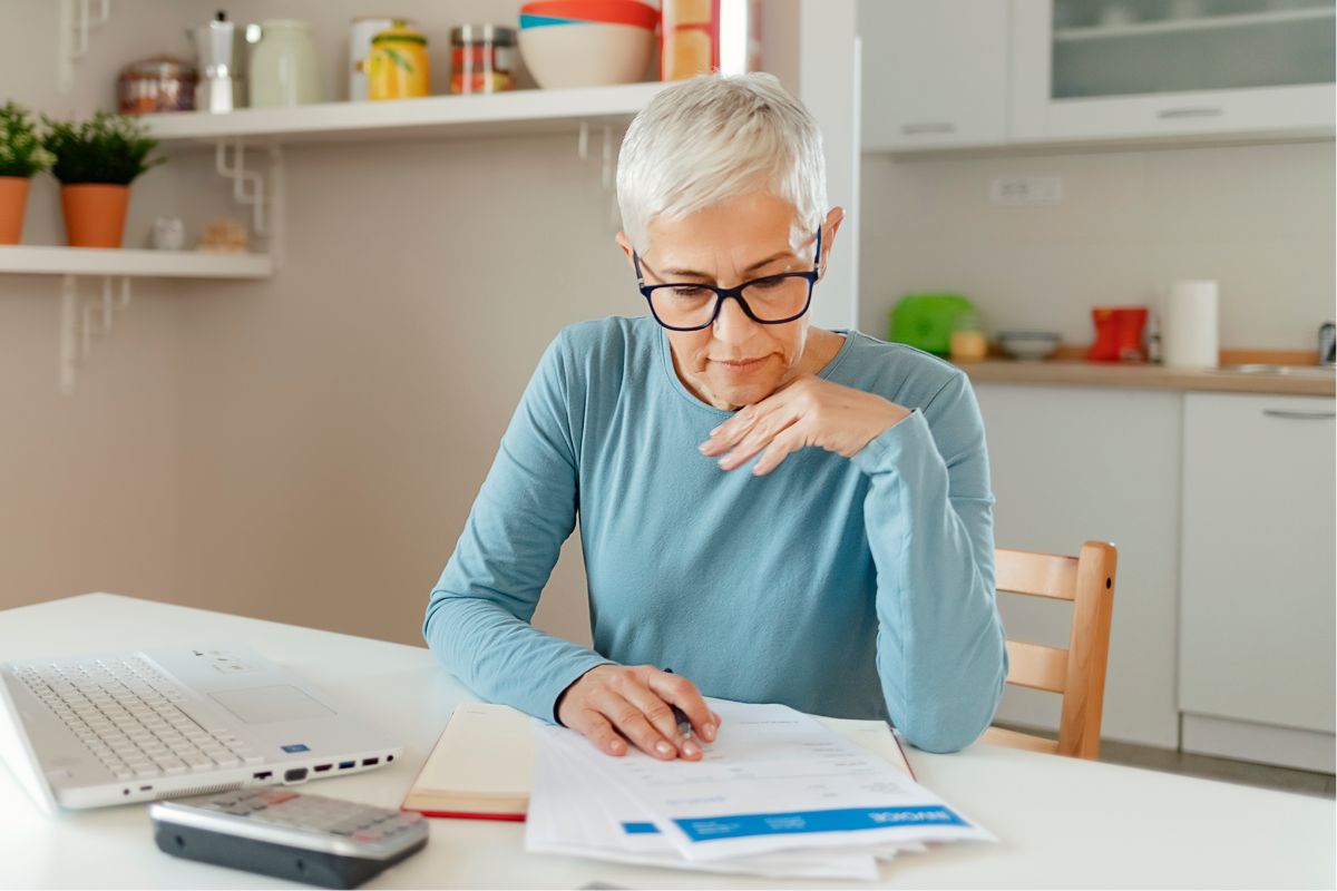 A picture of an elderly woman looking at her finances.