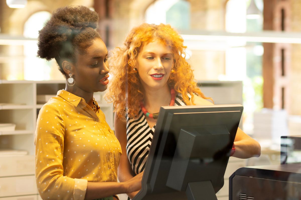 A picture of a customer talking to a cashier.