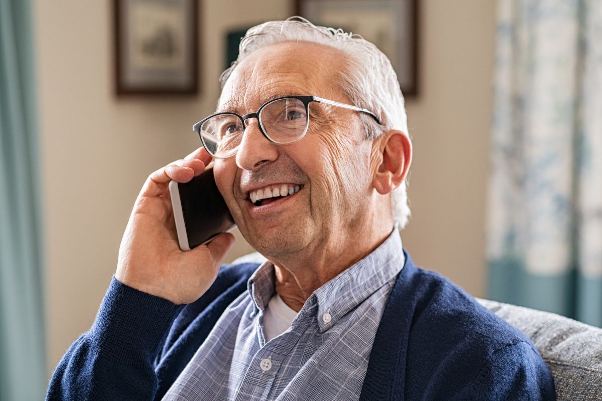 A picture of an elderly man calling someone.