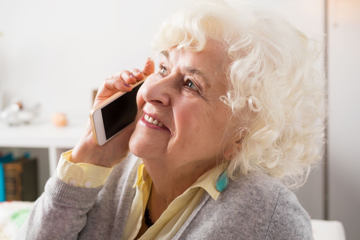 A picture of an elderly woman calling someone.