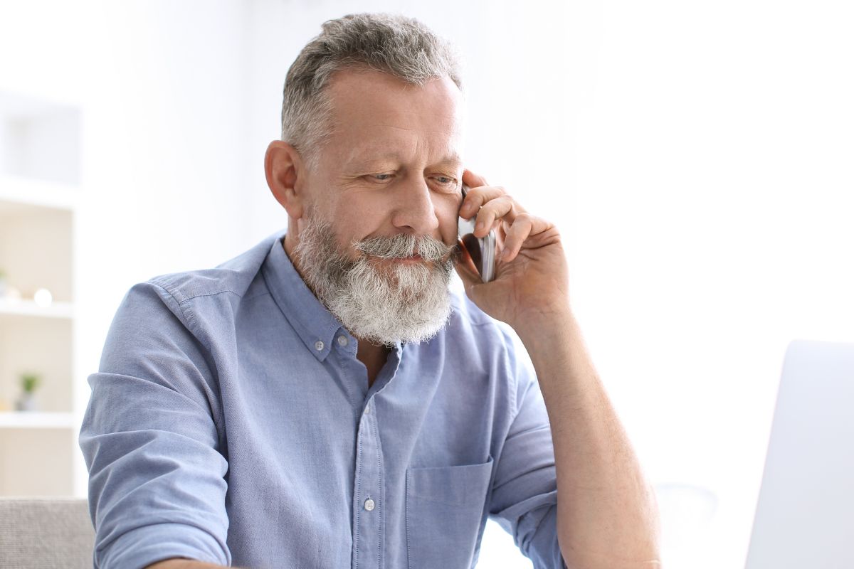 A picture of an elderly man calling someone.
