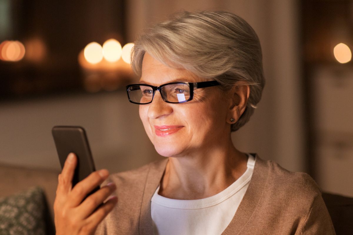 A picture of an elderly woman looking at their phone.