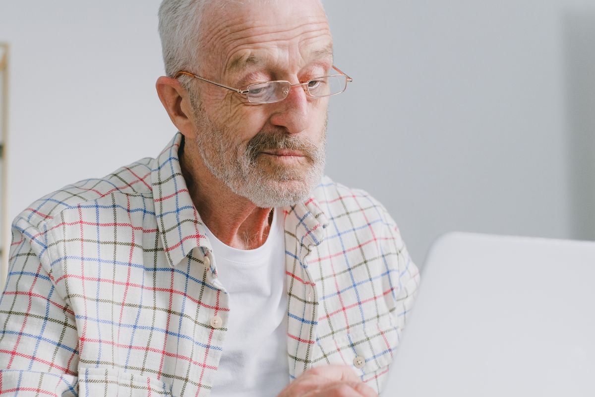 A picture of an elderly man using their laptop.