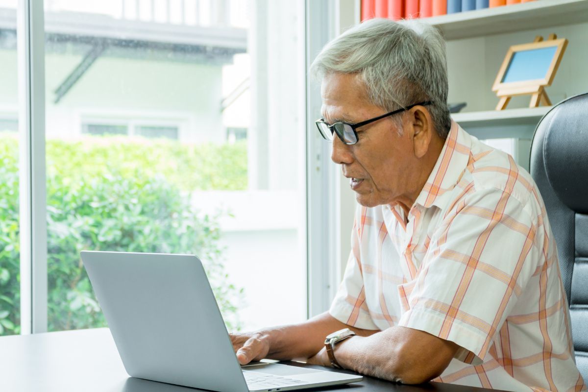 A picture of an elderly man using their laptop.