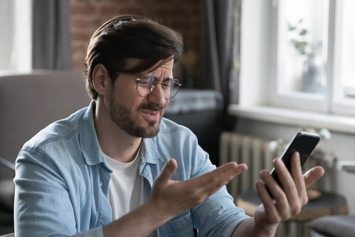 A picture of someone getting irritated at his phone.