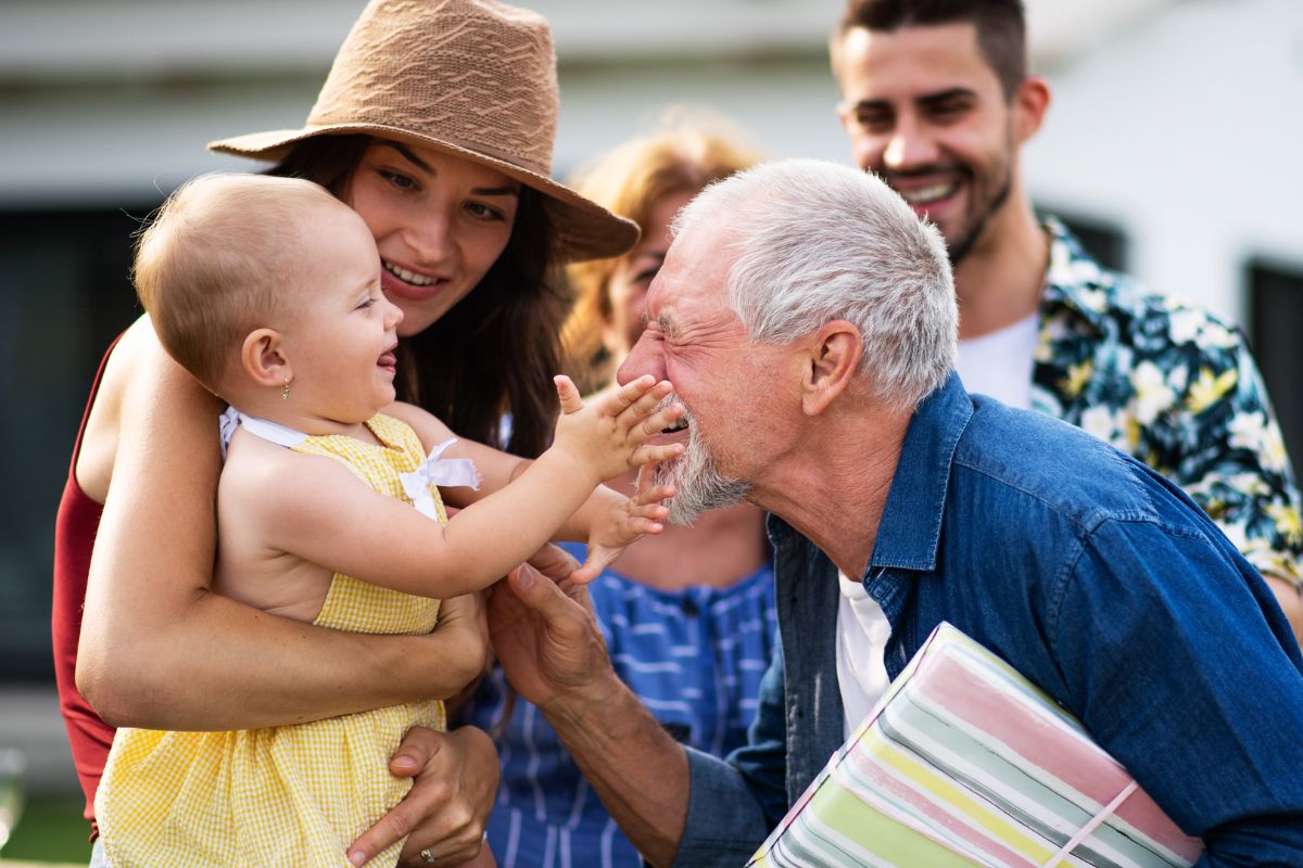 A picture of a senior citizen playing with his grandchildren.