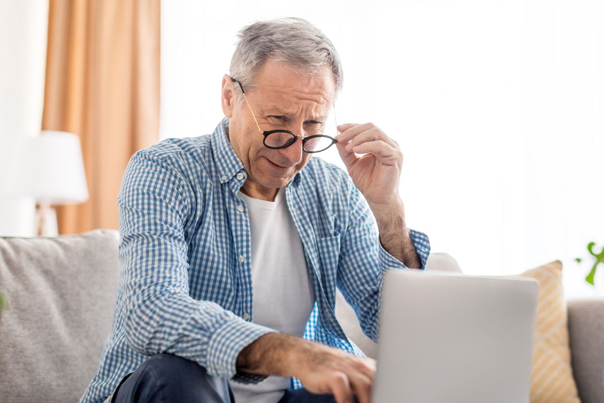 A picture of an elderly man reading something.