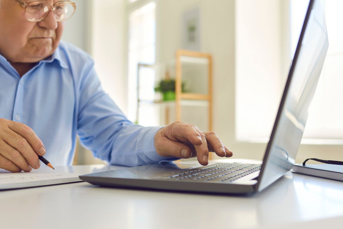 A picture of an elderly person researching something.