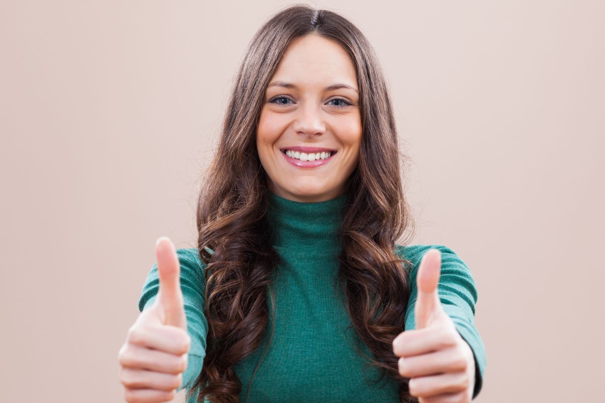 An image of a woman doing an ok sign.