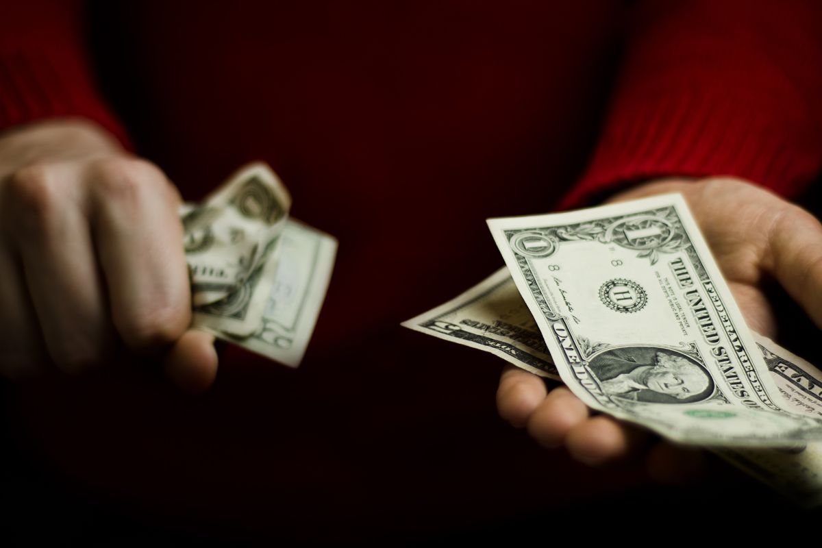 A picture shows a man's hand holding money.