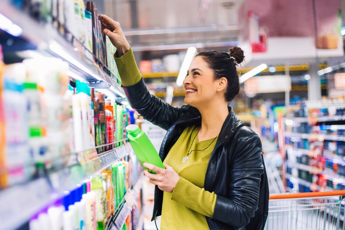 An image shows a woman comparing prices.