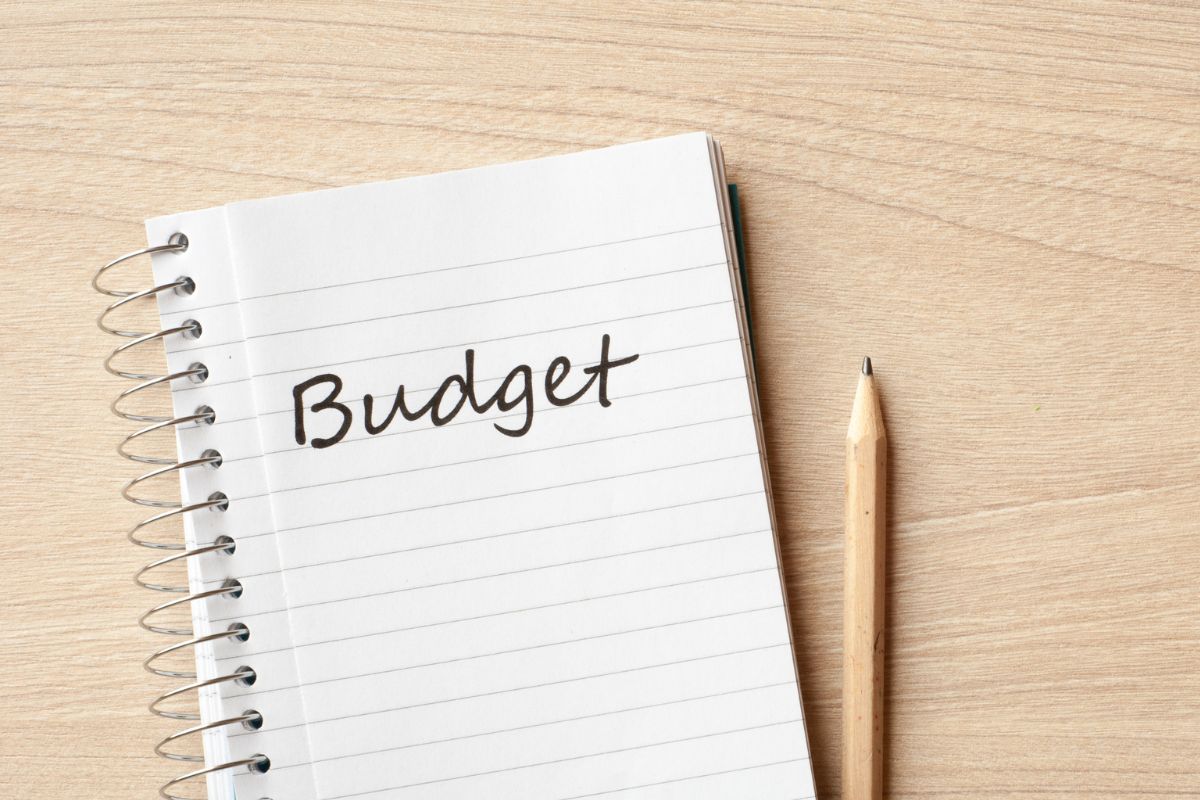 A picture of a pen and a notebook with budget wording.