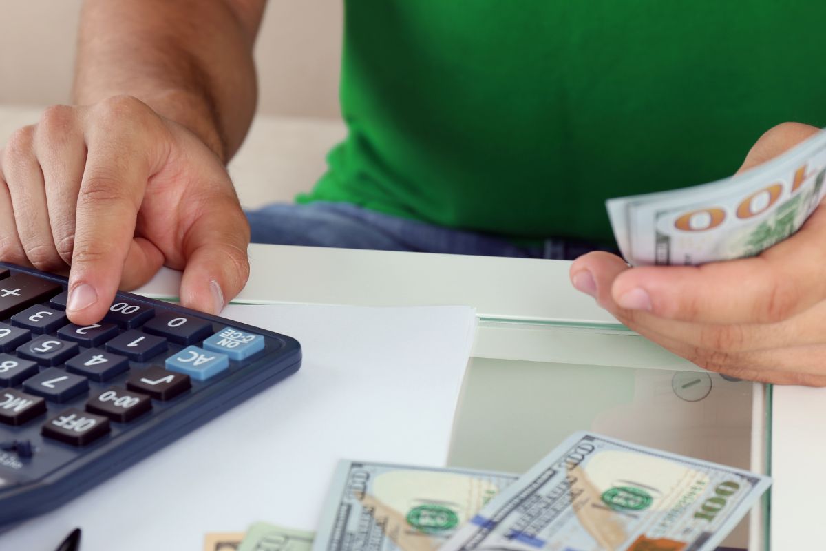 A picture of a man calculating money.