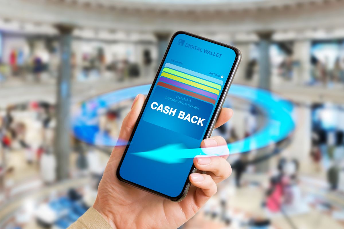 An image shows a woman's hand using a cash back app.