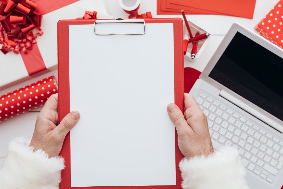 An image shows a man's hand planning for Christmas.