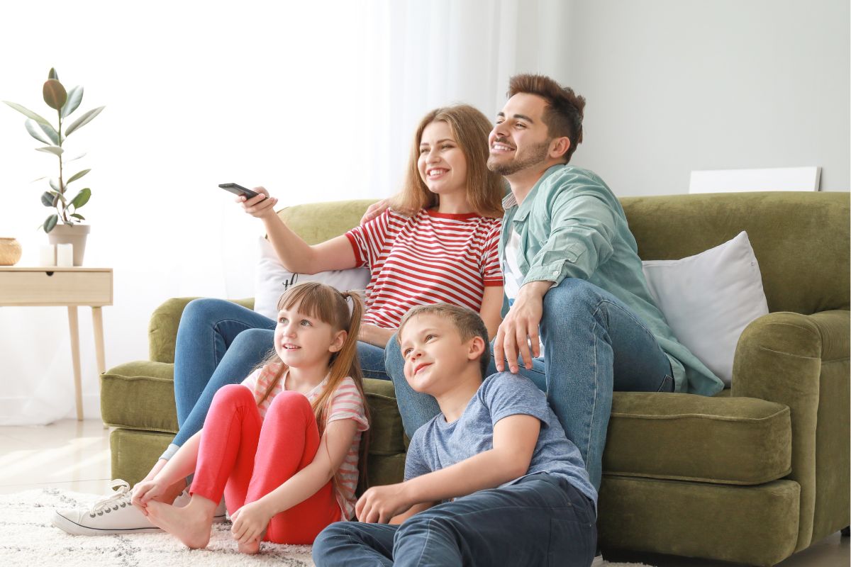 A picture of a family watching a movie together.