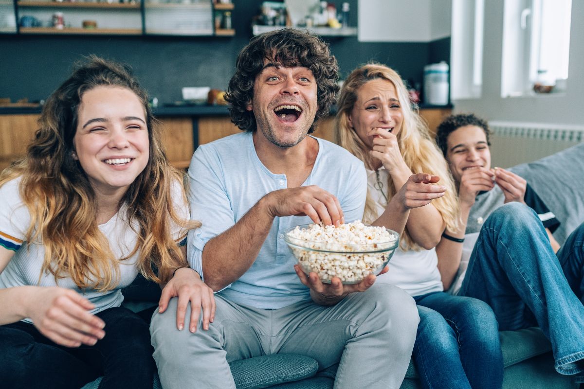 A picture shows a family laughing while watching a movie.