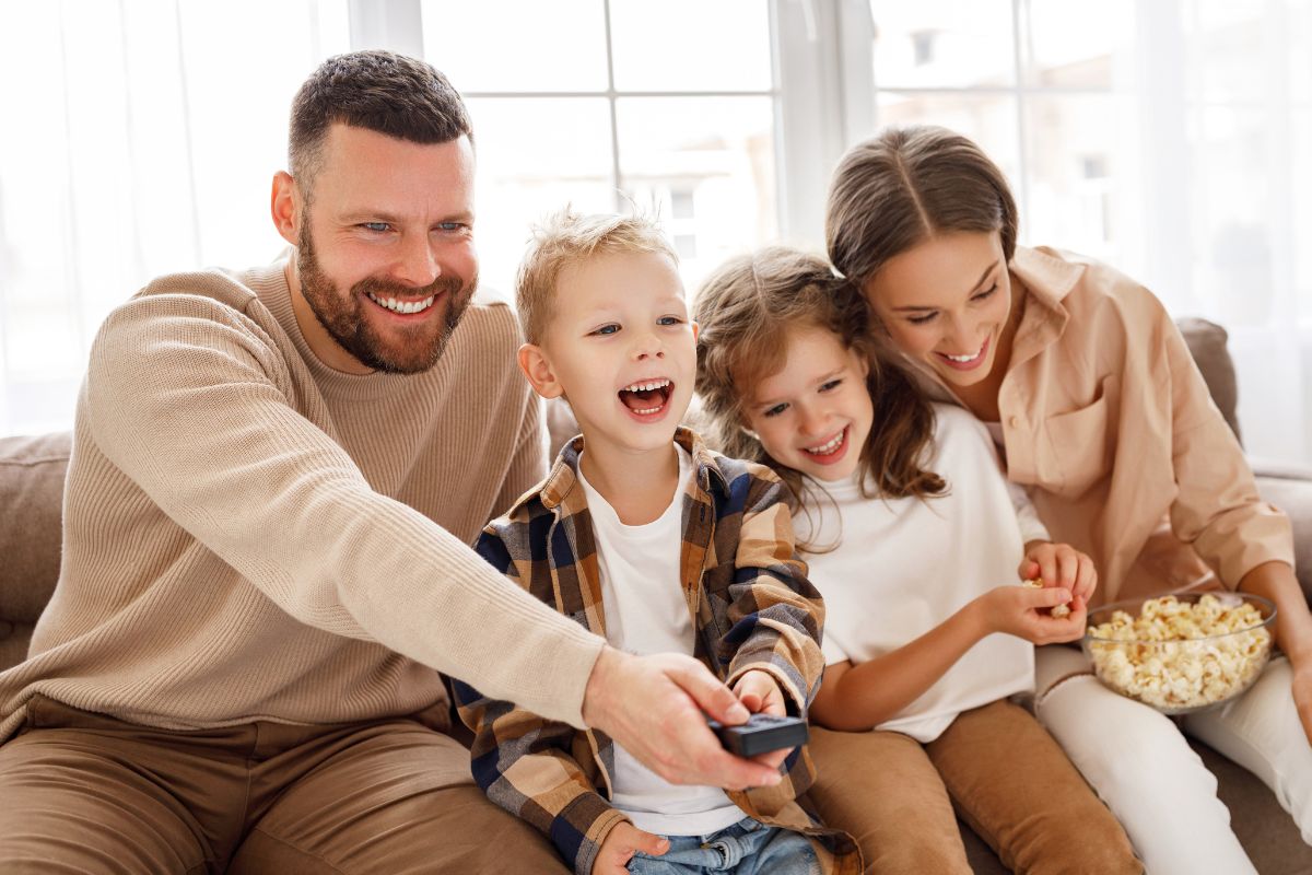 A picture of a family watching a movie together in the living room.