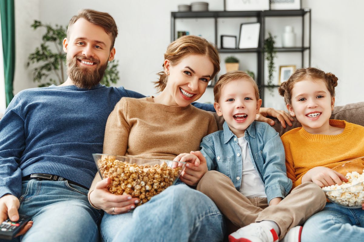 An image of a family eating popcorn while watching a movie.