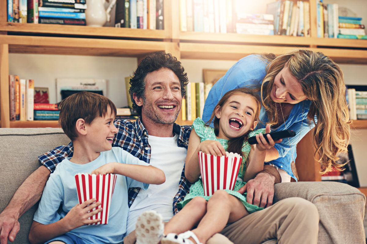 The picture of a family having fun by watching a movie.