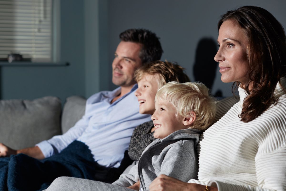An image of parents watching a movie with their kids.