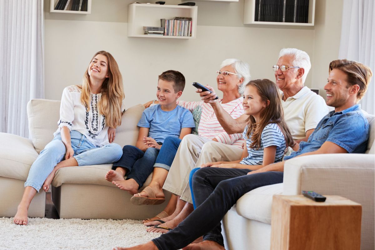 A picture of a family watching a movie at home.