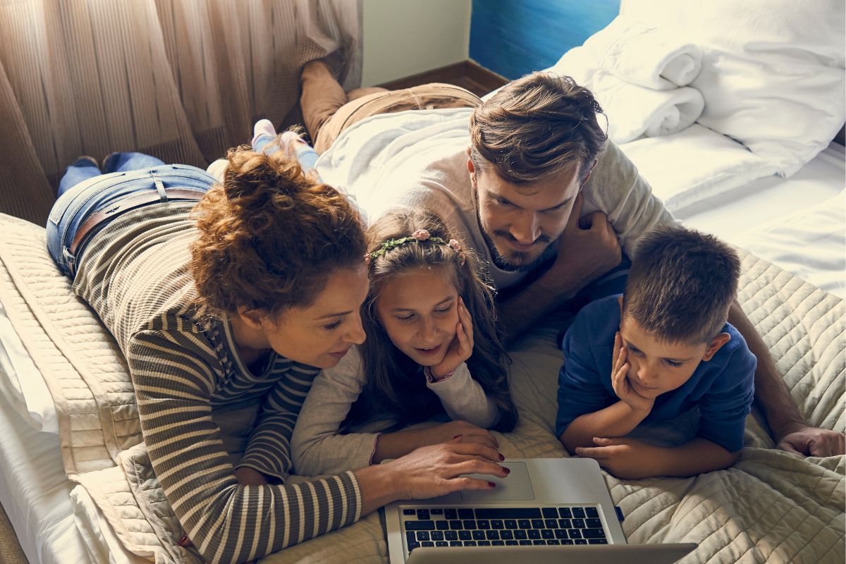 An image of a family watching a movie on their laptop.