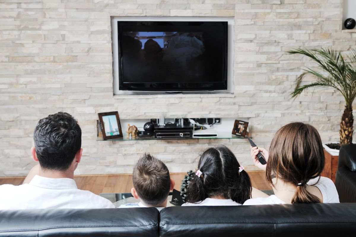 A picture of a family is watching a movie together.