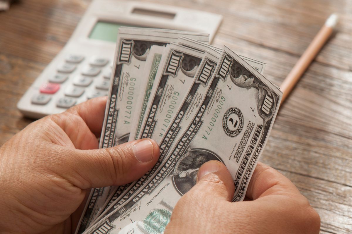 A picture of a man's hand is tracking his money.