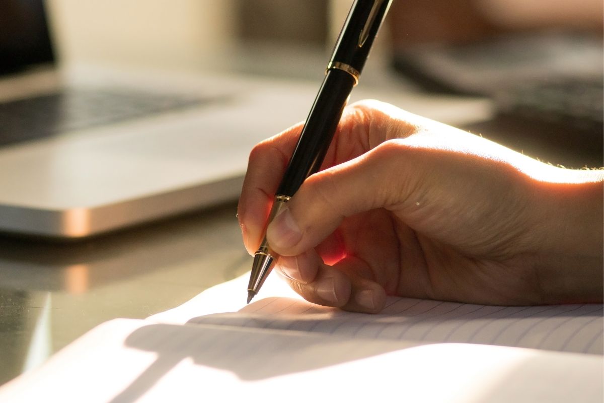 An image tells about a man's hand making a list.