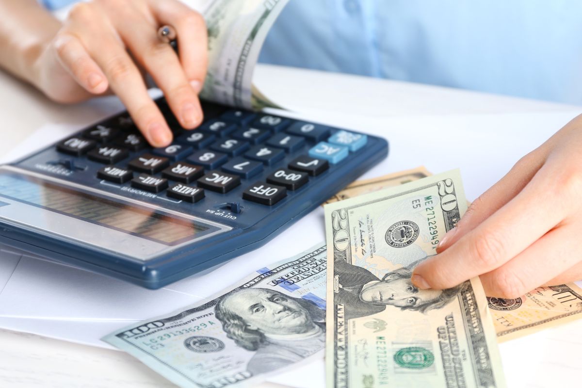 An image shows a woman calculating her money.