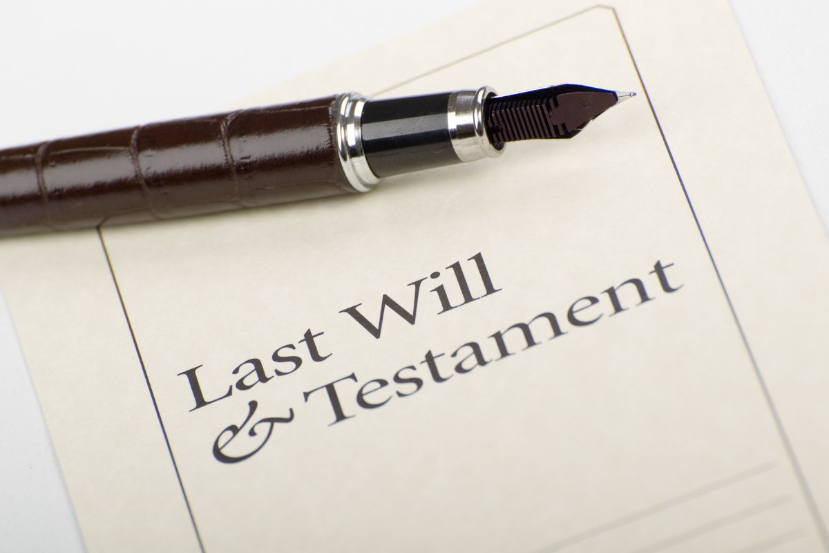 An image shows a last will paper and pen.