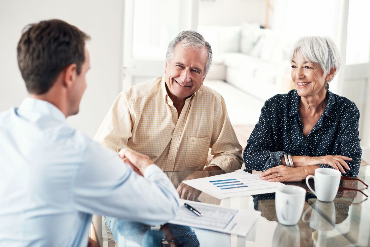 An image of a senior couple talking to their financial advisor.