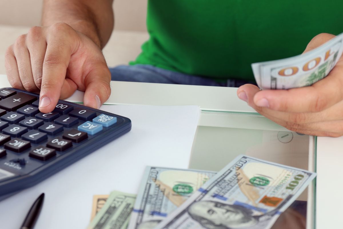 An image shows a man budgeting money.