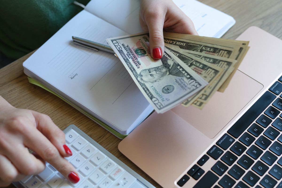 An image shows a woman budgeting her money.