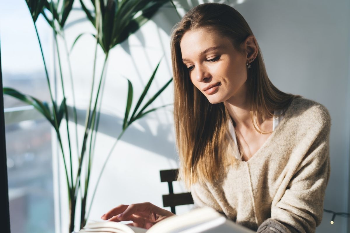 An image of a calm woman reading a book.