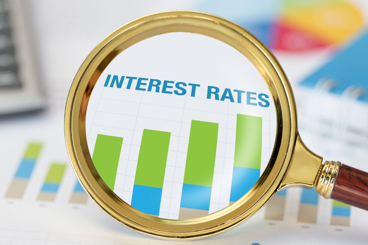 An image shows a magnifying glass and interest rates wording.