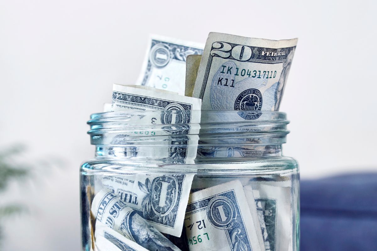 An image shows a jar with money savings.
