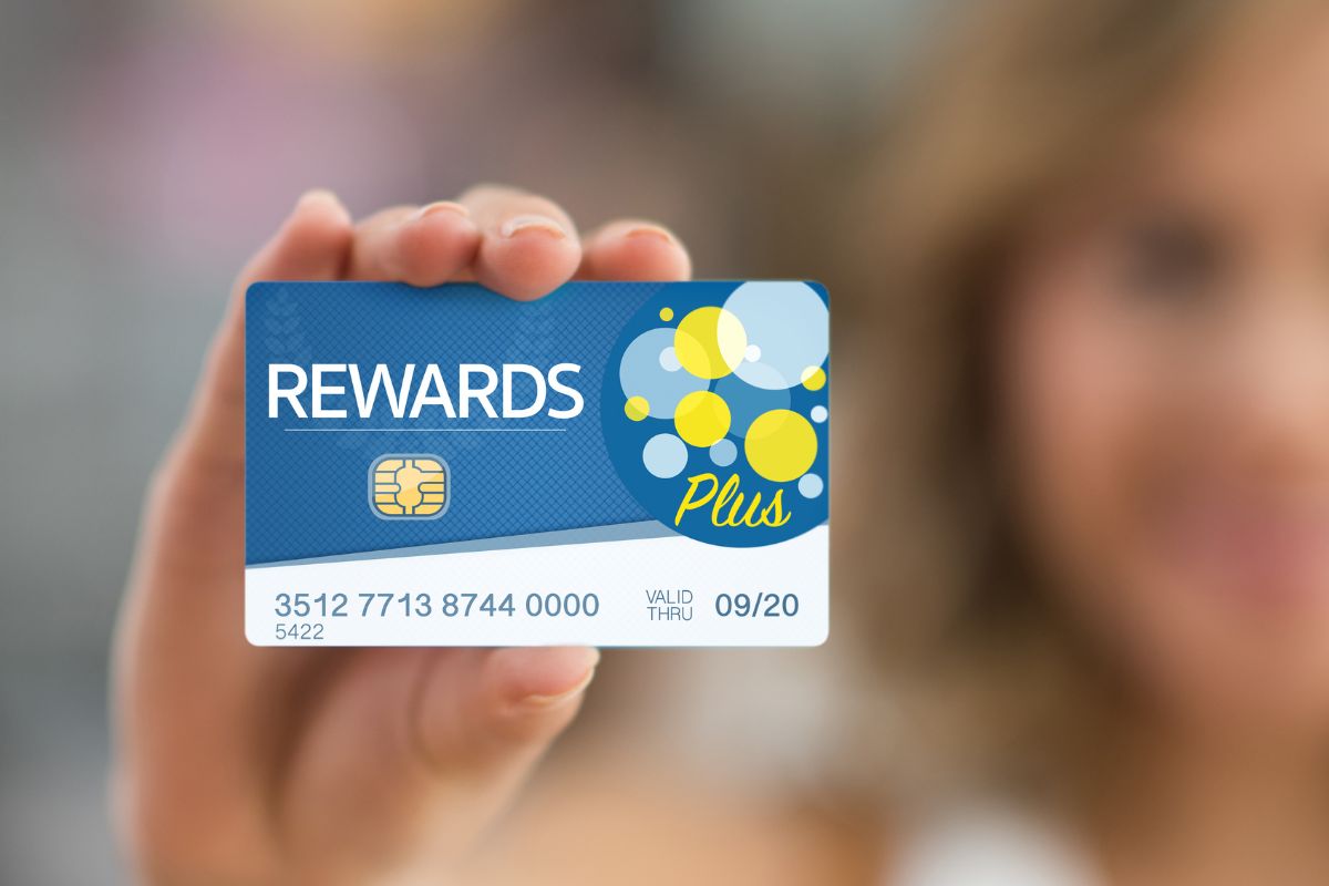 A picture of a woman holding a reward card.