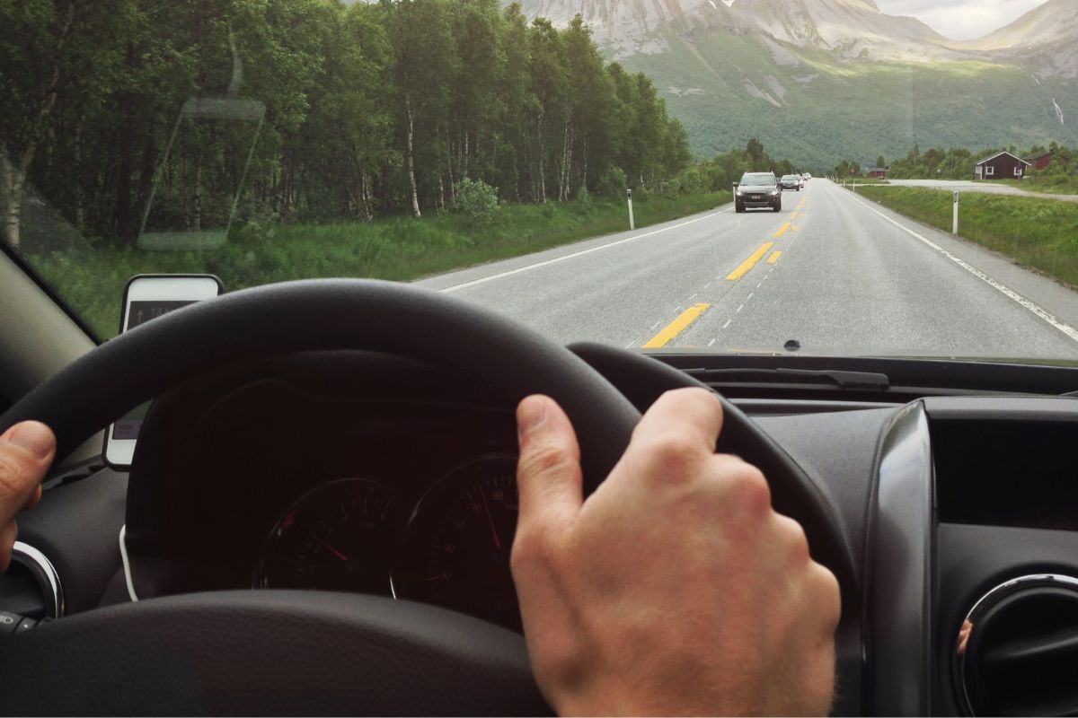 An image shows a man driving a car.