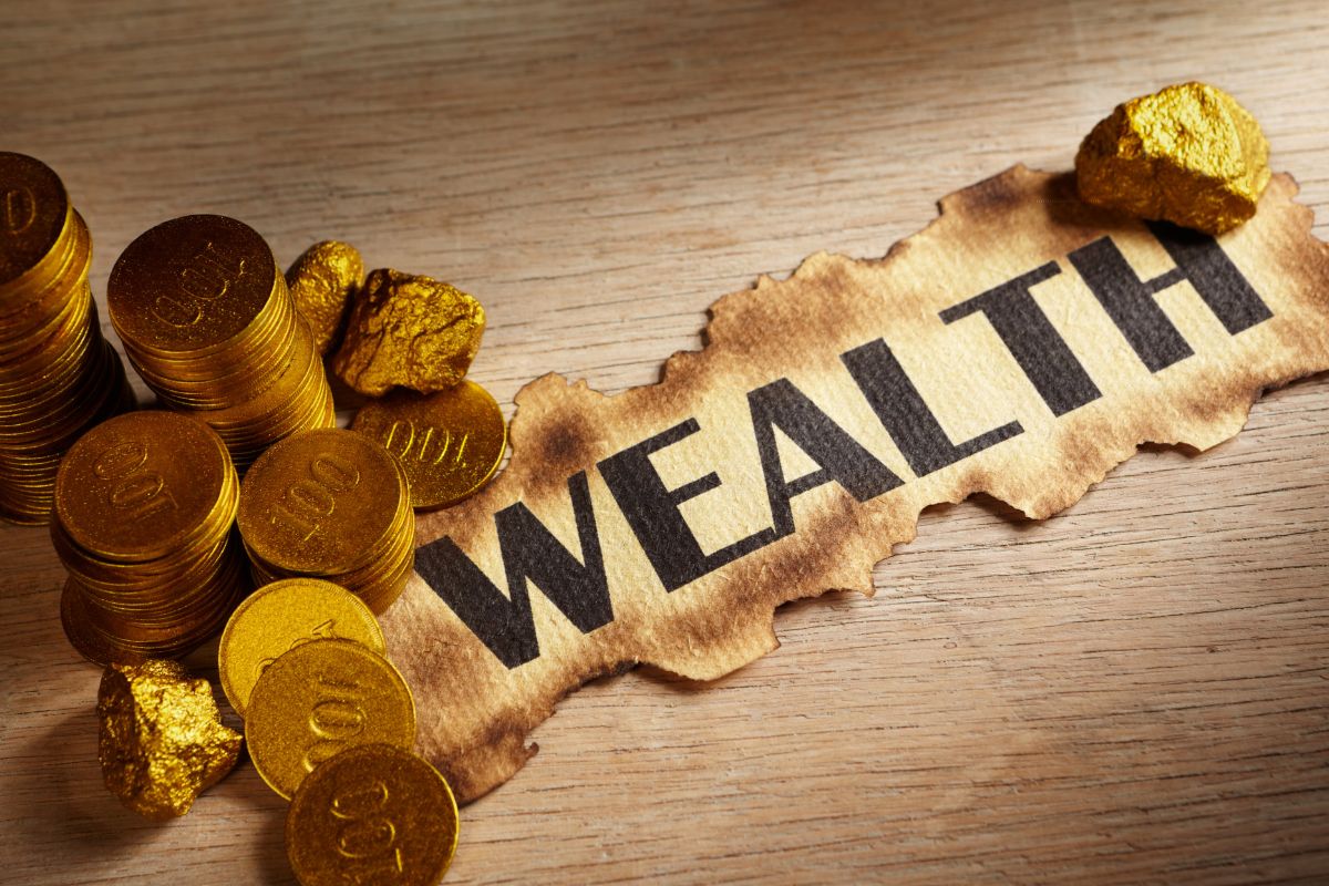 A picture shows golden coins and wealth wording on paper.