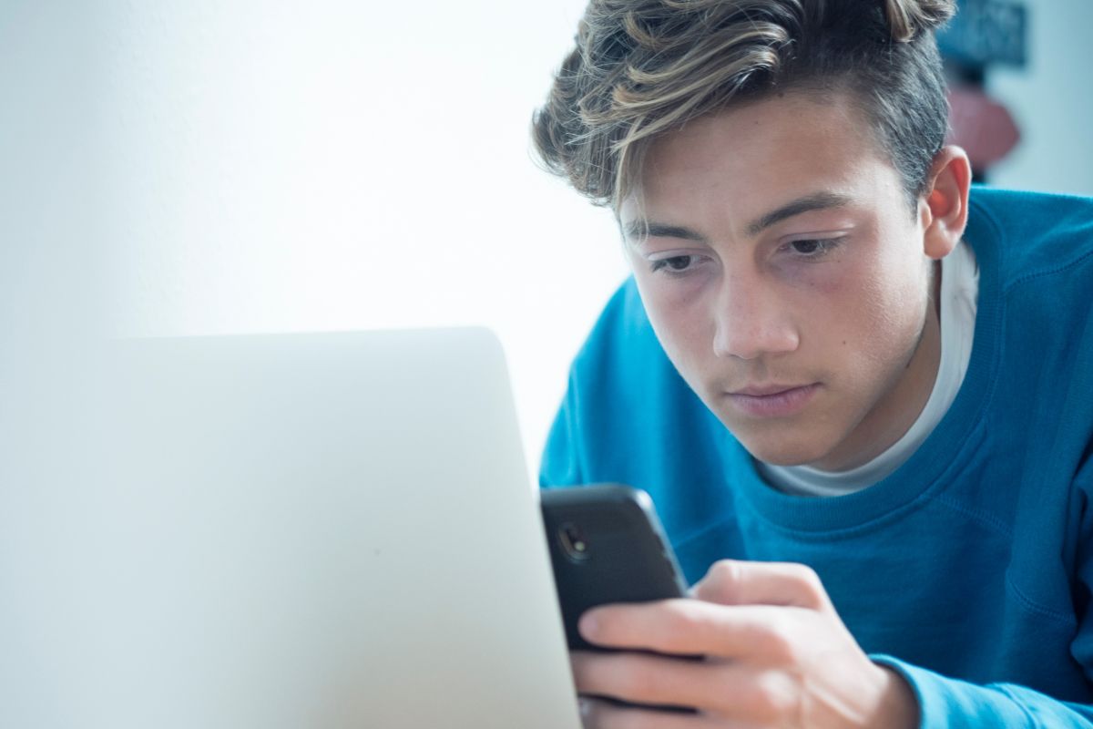 A picture of a teen using his phone.