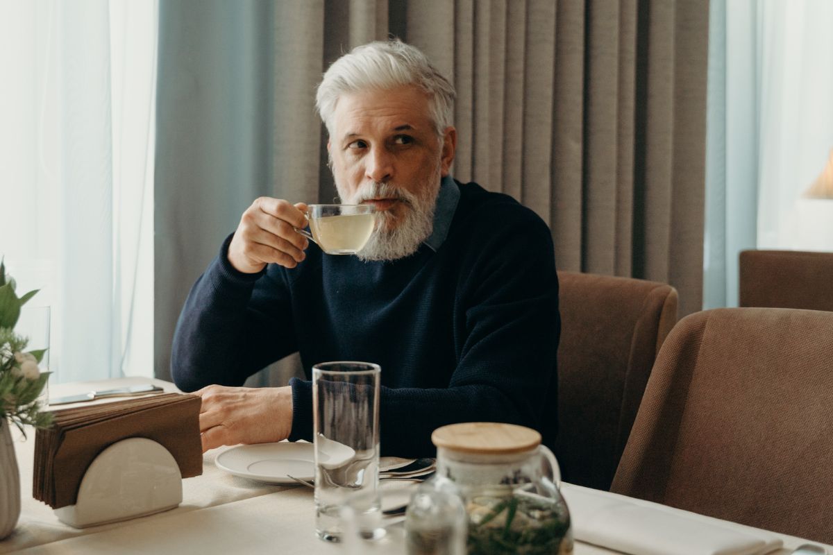 A picture of an elderly man drinking.