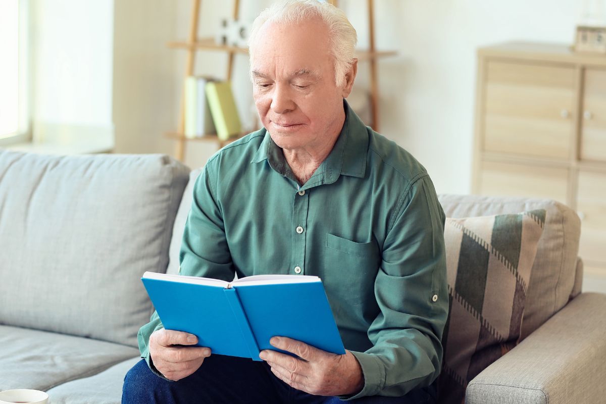 A picture of an elderly man reading something.