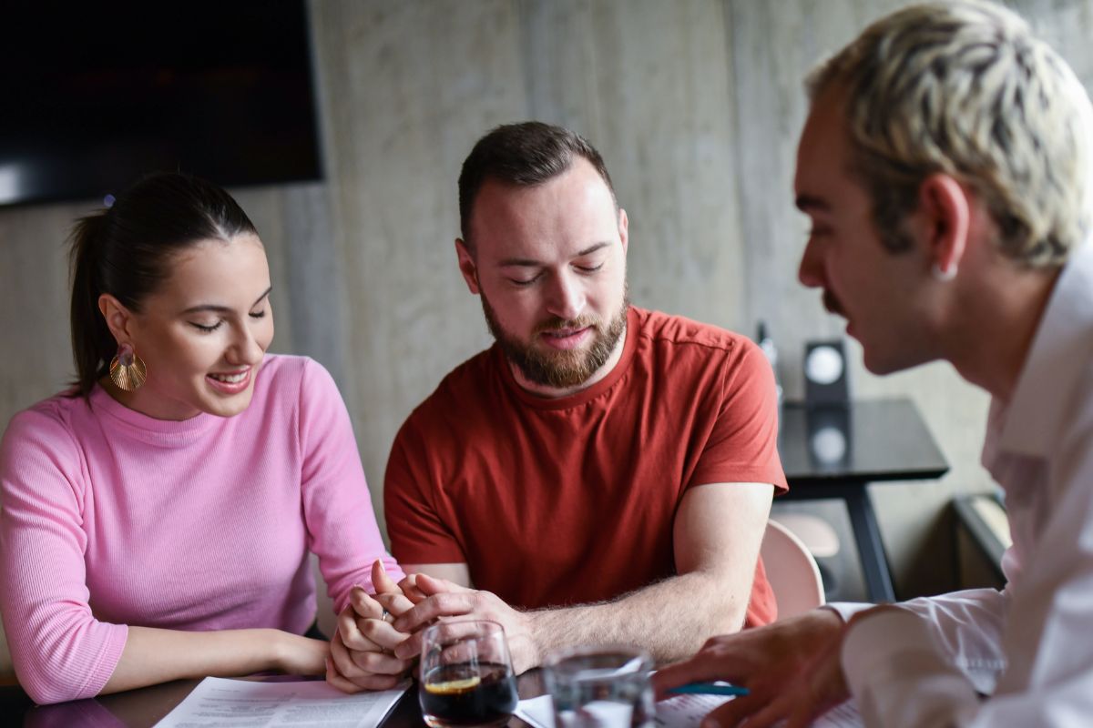 A picture of a couple talking to someone.