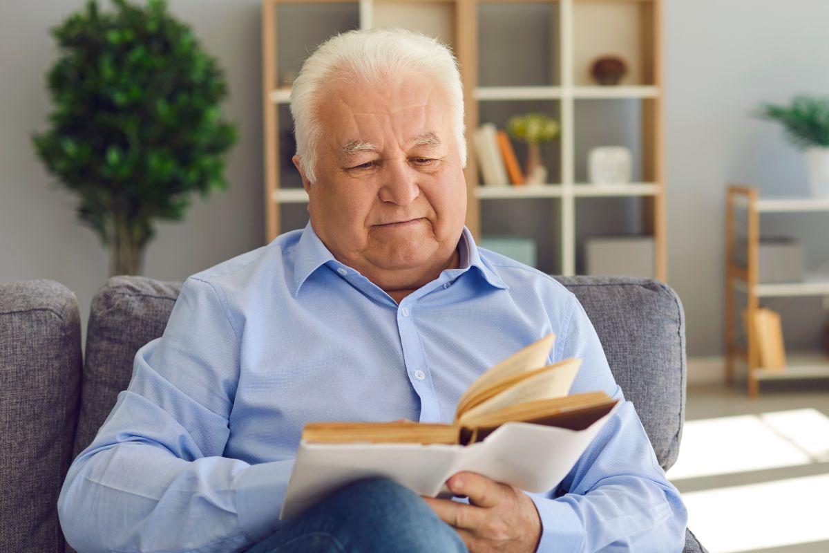 A picture of an elderly man reading something.