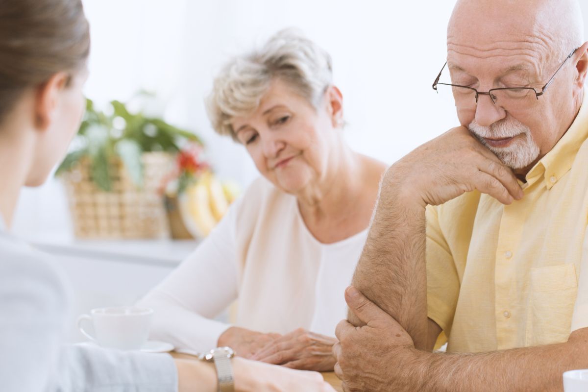 A picture of an elderly couple consulting something.