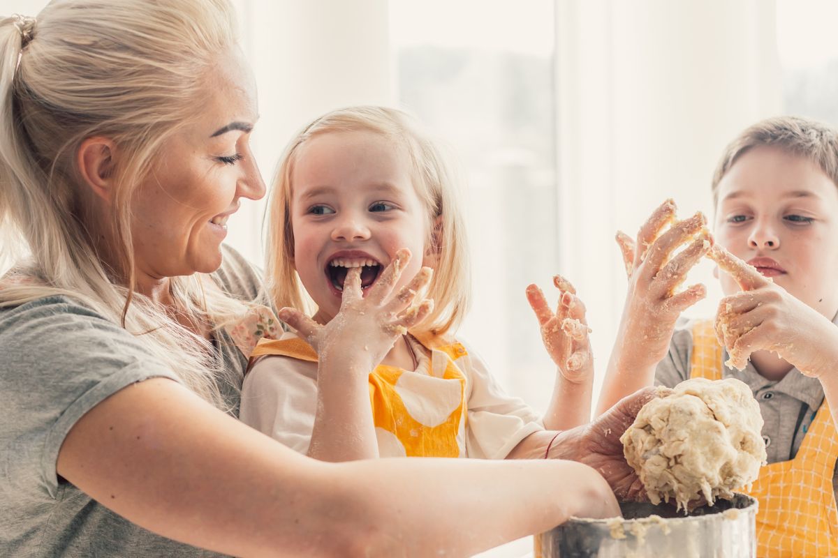 A picture of a mom and her kids baking.