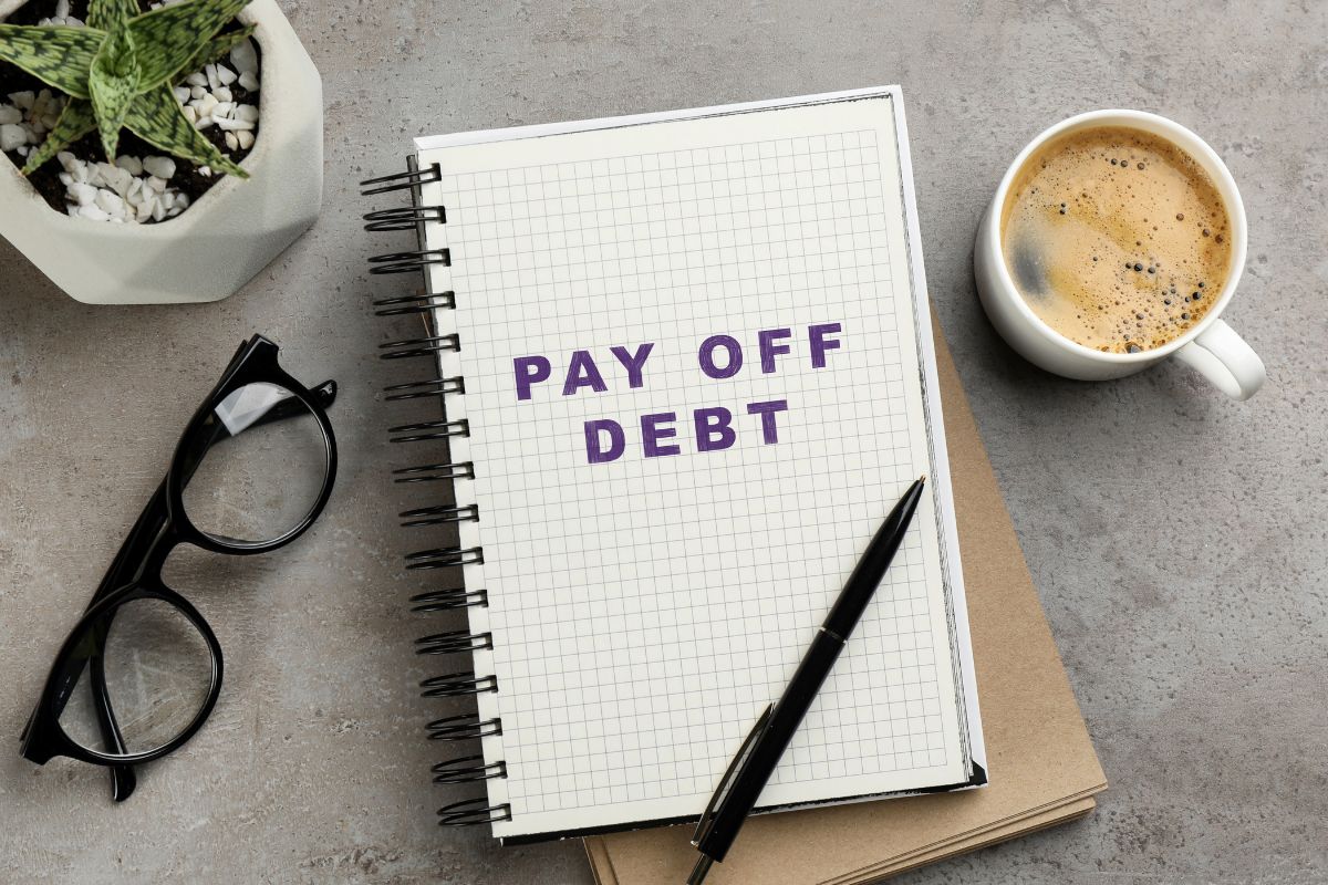A picture of a notebook with a note saying "pay off debt".